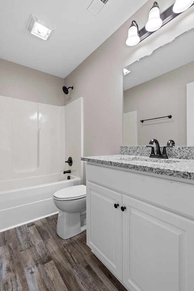 full bathroom featuring vanity, toilet, wood-type flooring, and tub / shower combination