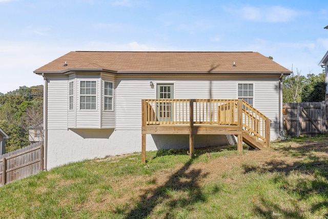 back of property featuring a wooden deck and a yard