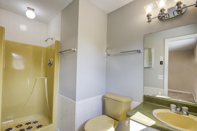 bathroom with vanity, a textured ceiling, toilet, and walk in shower