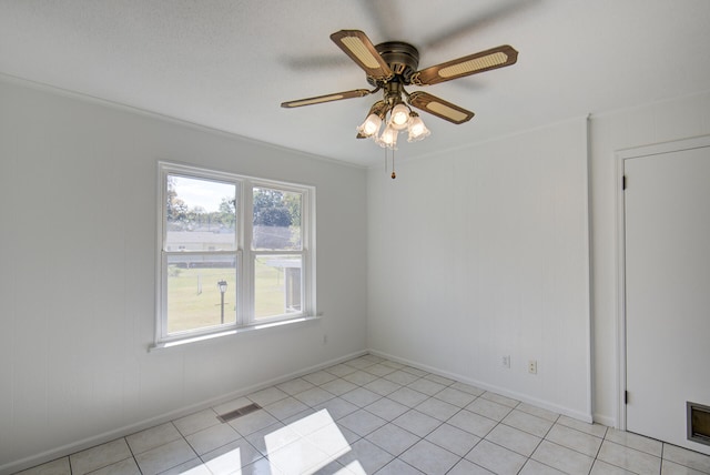 tiled spare room with ceiling fan and crown molding