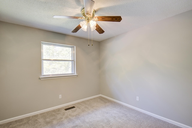 carpeted empty room with ceiling fan and a textured ceiling