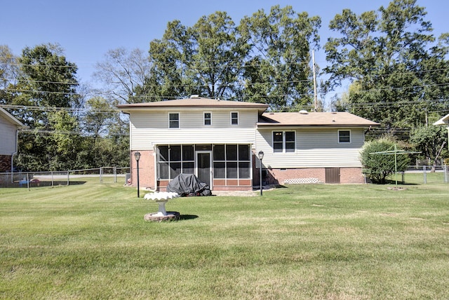 rear view of house with a lawn and a sunroom