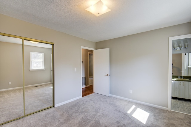 unfurnished bedroom featuring connected bathroom, light carpet, and a closet