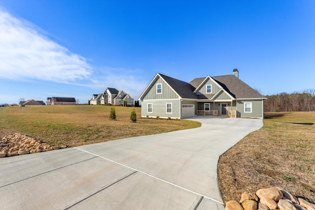 view of front of house featuring covered porch, a garage, and a front lawn