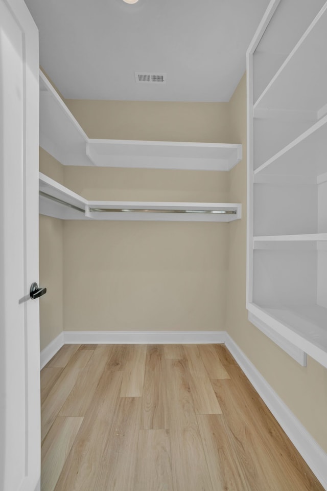 walk in closet with wood-type flooring