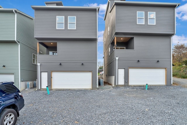 view of front of property with a garage, central AC, and a balcony