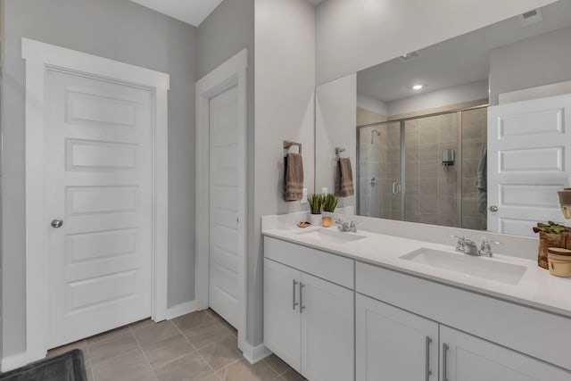 bathroom with tile patterned flooring, vanity, and a shower with shower door