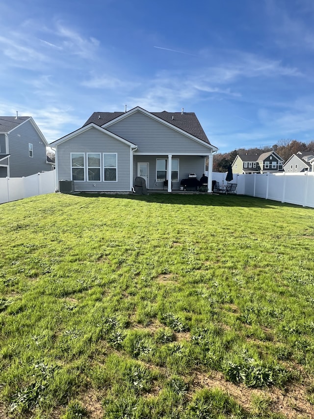 rear view of property featuring a lawn