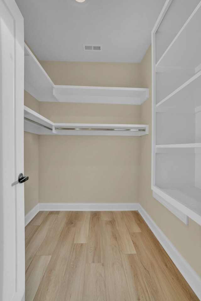 spacious closet with hardwood / wood-style flooring