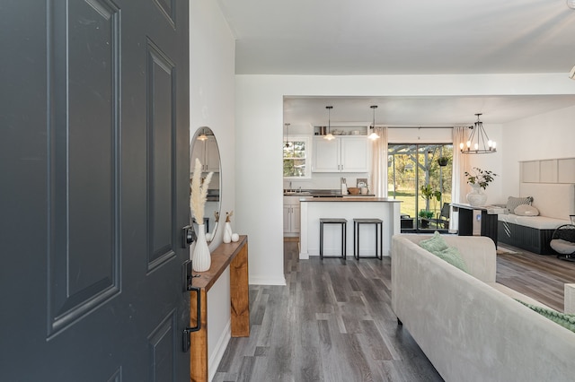 entrance foyer with an inviting chandelier and dark hardwood / wood-style floors