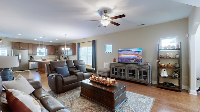 living room with light hardwood / wood-style flooring and ceiling fan