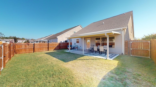 back of house with a patio and a lawn