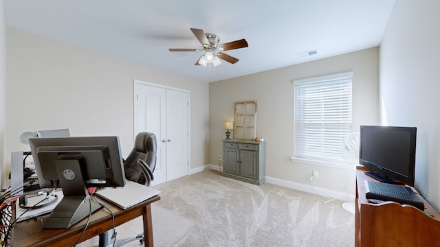 carpeted office space featuring ceiling fan