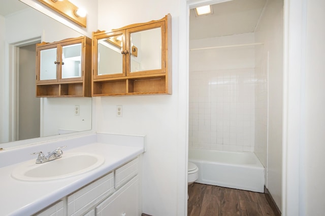 full bathroom with vanity, toilet, wood-type flooring, and tiled shower / bath