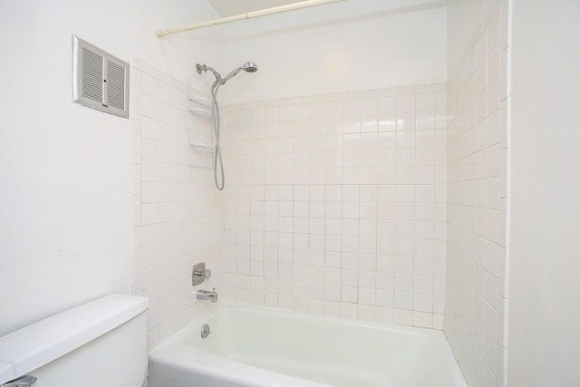 bathroom featuring tiled shower / bath combo and toilet