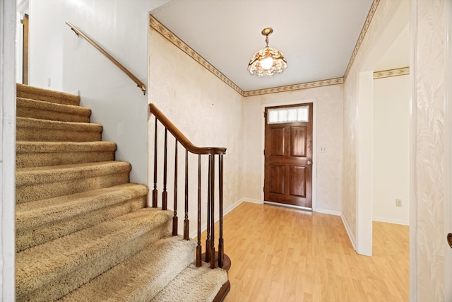 entryway with ornamental molding and hardwood / wood-style flooring