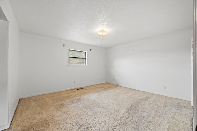 unfurnished room with a textured ceiling and light colored carpet