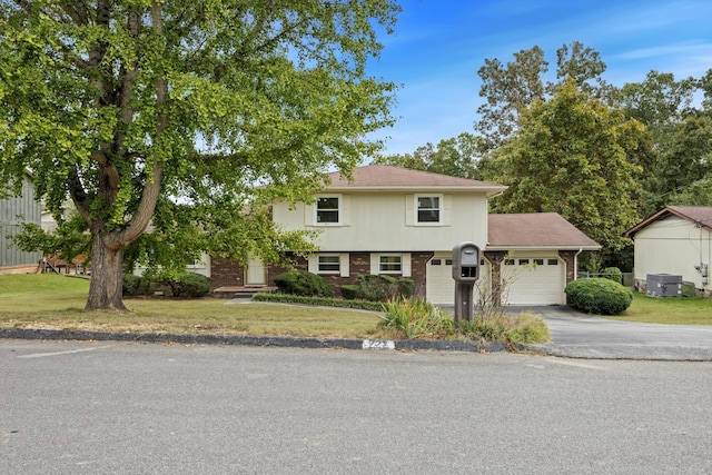 view of front of home featuring a front yard, a garage, and cooling unit