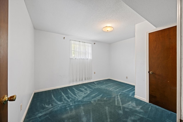 carpeted empty room with a textured ceiling