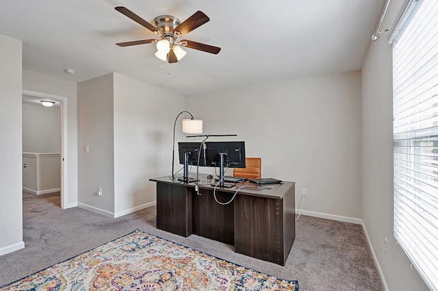 carpeted office space featuring ceiling fan