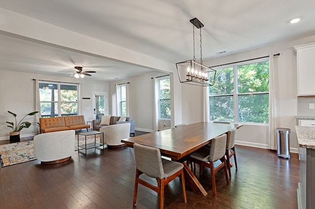 dining space featuring dark wood-type flooring and ceiling fan with notable chandelier