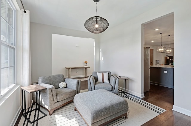 sitting room with sink, an inviting chandelier, and dark hardwood / wood-style flooring