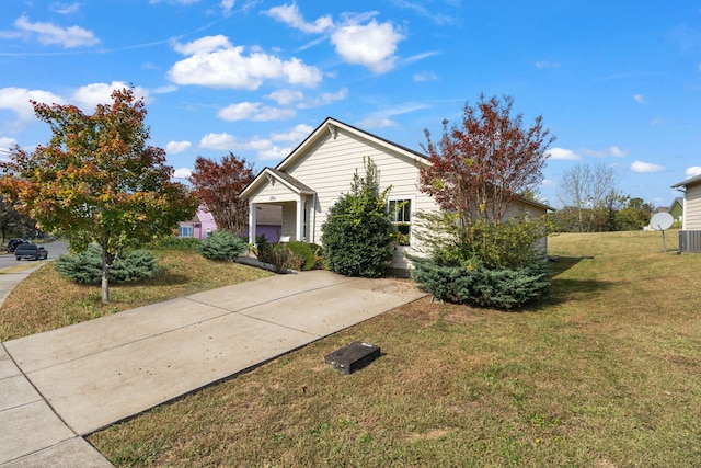 view of front facade with a front yard, central AC unit, and a garage