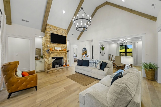 living room featuring light wood-type flooring, a fireplace, beamed ceiling, high vaulted ceiling, and a chandelier