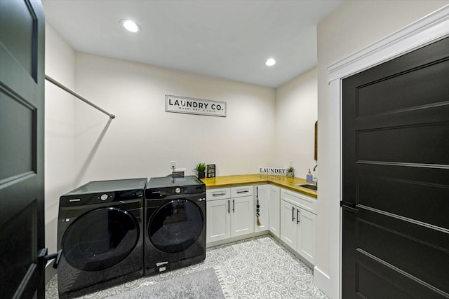 washroom with washing machine and dryer and cabinets