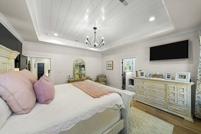 bedroom featuring crown molding, light hardwood / wood-style flooring, a notable chandelier, and a tray ceiling