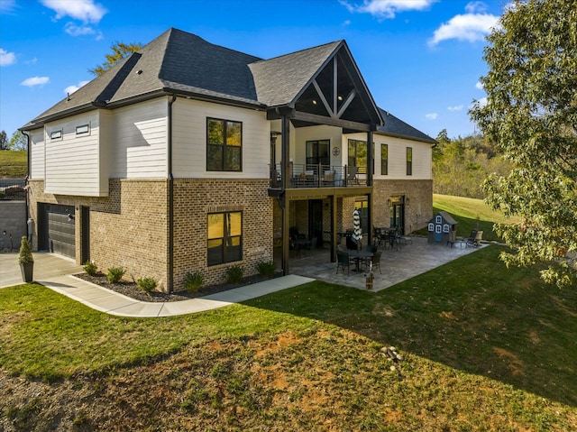 back of house featuring a patio, a balcony, a yard, and a garage