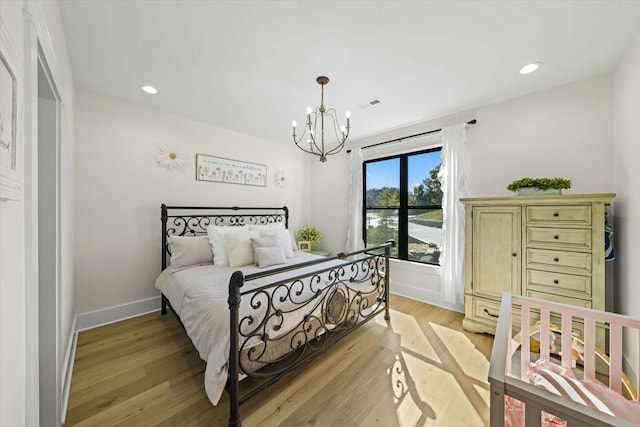 bedroom featuring light hardwood / wood-style flooring and a chandelier