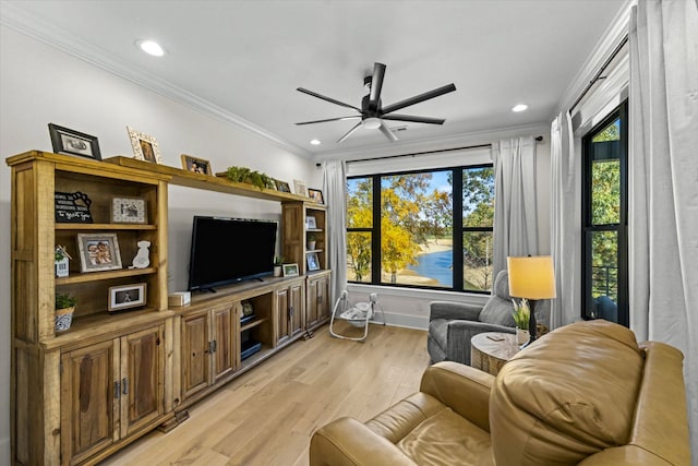 living room featuring ornamental molding, light wood-type flooring, and ceiling fan