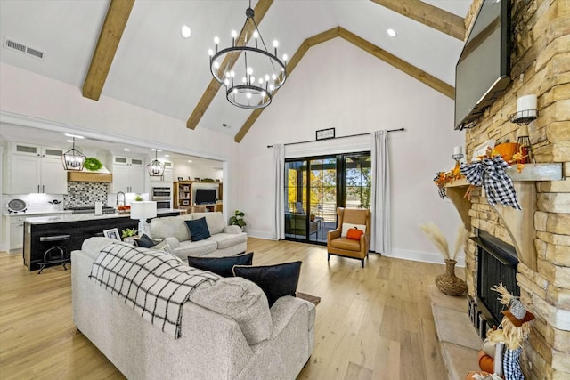1878 Ferry Hill Rd, Dandridge, TN 37725 - living area with high vaulted ceiling, a stone fireplace, light wood-type flooring, a chandelier, and baseboards