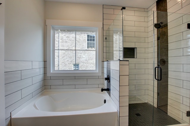 bathroom featuring tile walls and separate shower and tub