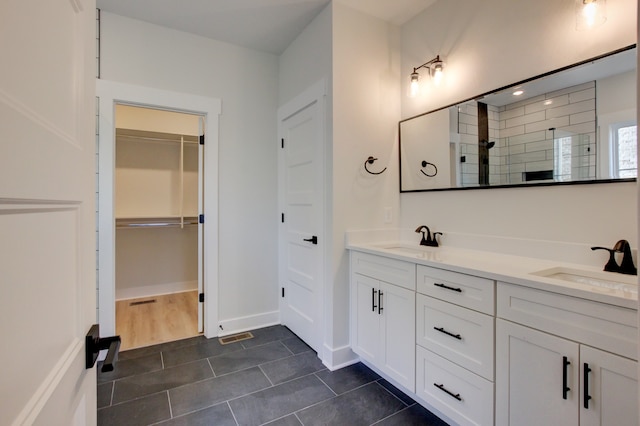 bathroom featuring vanity, tile patterned floors, and tiled shower