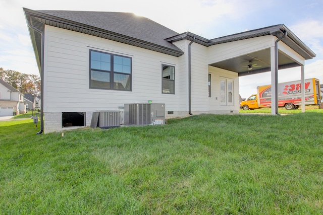 rear view of house with central air condition unit, a yard, and ceiling fan