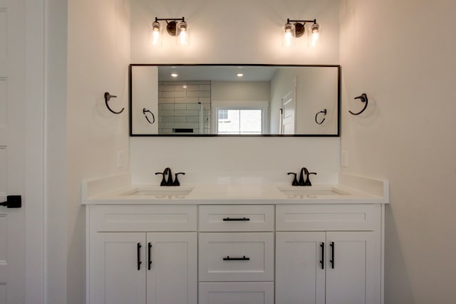 bathroom featuring walk in shower and vanity