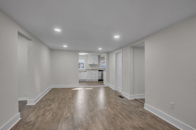 unfurnished living room with dark wood-type flooring