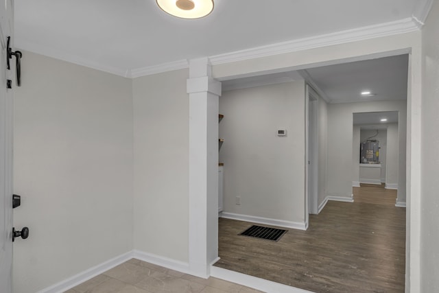 hallway featuring light hardwood / wood-style flooring, ornamental molding, and a barn door