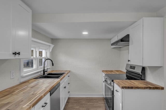 kitchen featuring appliances with stainless steel finishes, wood counters, and white cabinetry