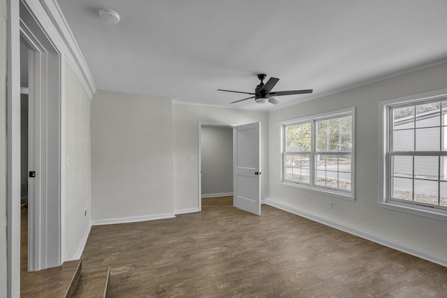 empty room featuring crown molding, dark hardwood / wood-style floors, and ceiling fan