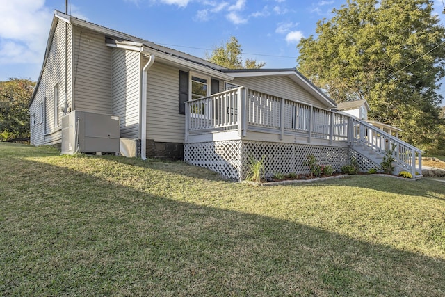 view of home's exterior with a wooden deck and a yard