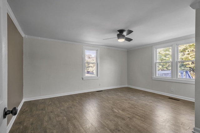 empty room with crown molding, a healthy amount of sunlight, and dark hardwood / wood-style flooring