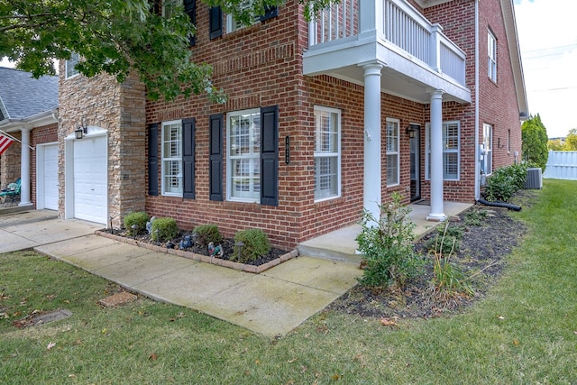 view of property exterior featuring a yard, a balcony, central AC unit, and a garage