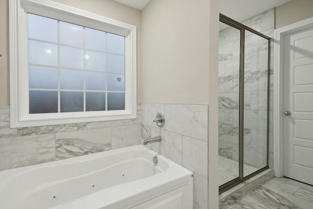 full bath with a whirlpool tub, marble finish floor, and a shower stall