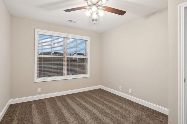 unfurnished room with ceiling fan, baseboards, visible vents, and dark carpet