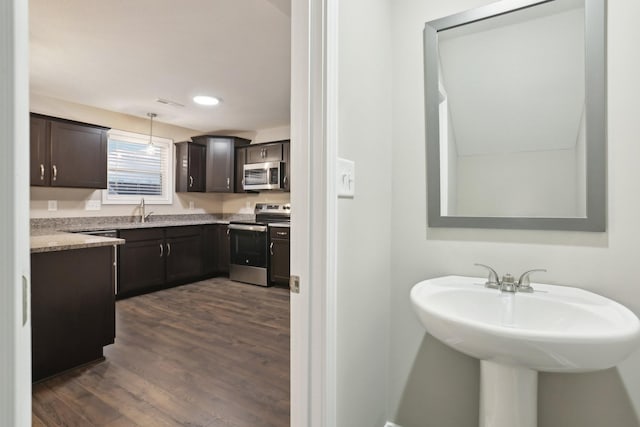 bathroom featuring visible vents, a sink, and wood finished floors