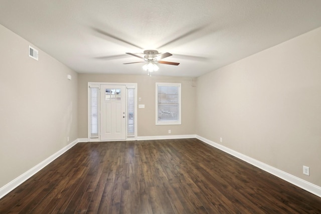 entrance foyer featuring a ceiling fan, visible vents, dark wood finished floors, and baseboards