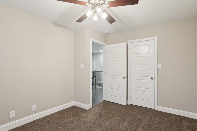 unfurnished bedroom with ceiling fan, baseboards, and dark colored carpet